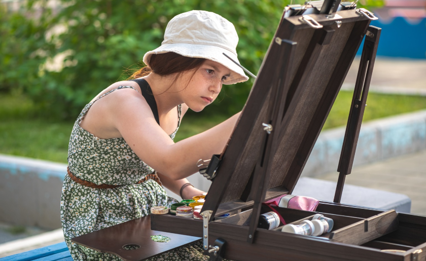 Woman painting outside.