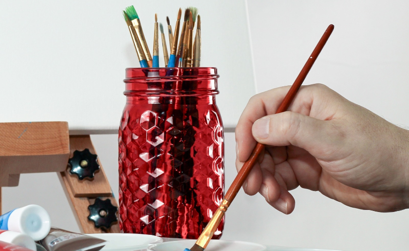 Mason jars holding brushes.