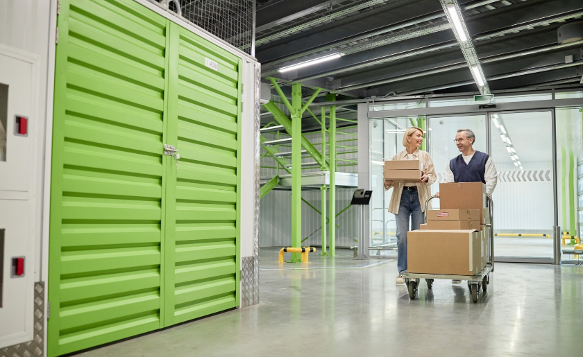 Couple with boxes of holiday decorations in storage facility.