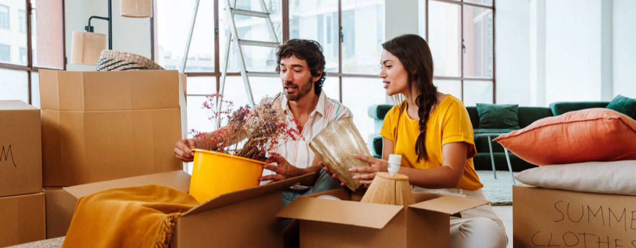 Young couple relocating in a new apartment using moving boxes